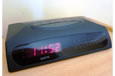 A black digital clock with red numbers that read 11:52.