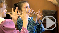 Two children playing making a cat's cradle with string