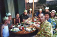 A large family sitting outside around a table having Christmas lunch.