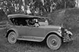 An old car with a metal body and a leather hood.