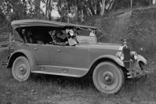 An old car with a metal body and a leather hood