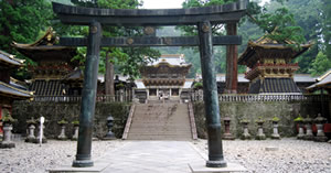 Japanese Torii gate in front of steps leading to three buildings. Japanese Torii gate in front of steps leading to three buildings.