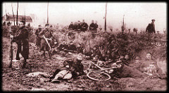 Soldiers in a field, one is lying on the ground next to a bicycle. Soldiers in a field, one is lying on the ground next to a bicycle.