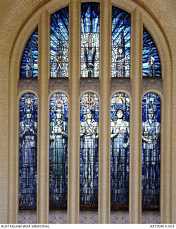 Arched stained-glass window with images of uniformed people in the five lower sections. Arched stained-glass window with images of uniformed people in the five lower sections.