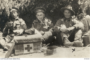 Soldiers sitting in the shade with a Red Cross box in front of them. Soldiers sitting in the shade with a Red Cross box in front of them.