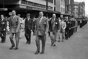 Men wearing medals marching along a city street Men wearing medals marching along a city street