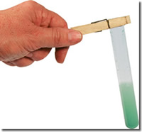 Hand holding a test tube with green liquid