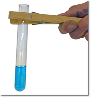 A hand with a test tube holder