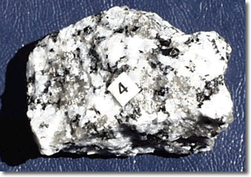 Graphic showing a rock with black, grey and white crystals